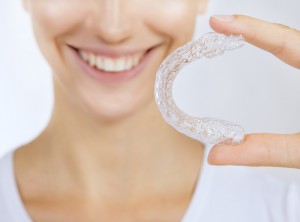 Woman holding an Invisalign retainer
